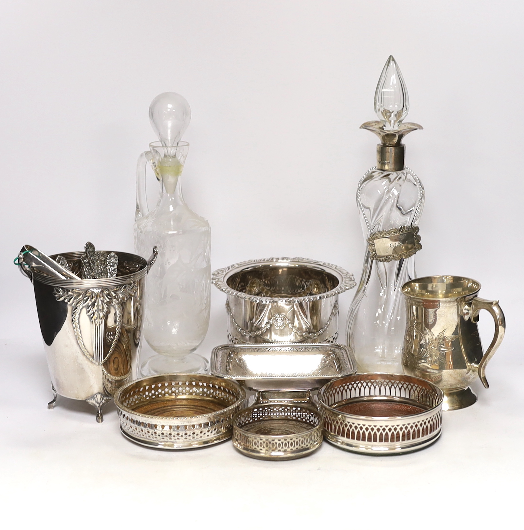 Two decanters; one with silver mount and one with etched body, together four wine coasters, a bucket raised on four feet, etc.